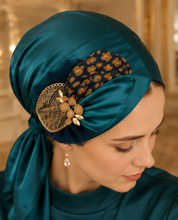 Load image into Gallery viewer, Gilded Teal fancy triangle tichel with deep teal silky base, navy floral print fabric band across crown, large gold filigree wire leaf brooch with peach blush oval stone and gold marquise leaf drops - five angles
