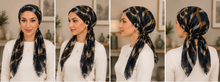 Load image into Gallery viewer, A four-panel collage showing a woman modeling a patterned headscarf or hijab worn in different views. The scarf has an abstract ikat-style pattern in navy, black, brown, and beige tones.
