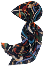 Load image into Gallery viewer, A lightweight square scarf with a multicolor abstract brushstroke pattern on a dark navy base, featuring fringed edges and styled in a loose knot against a plain white background.
